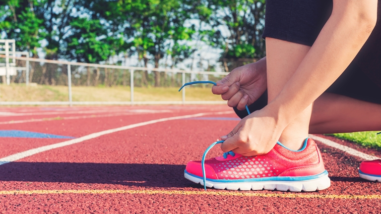 a female runner tying her shoelace