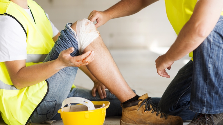 construction worker bandaging injured leg