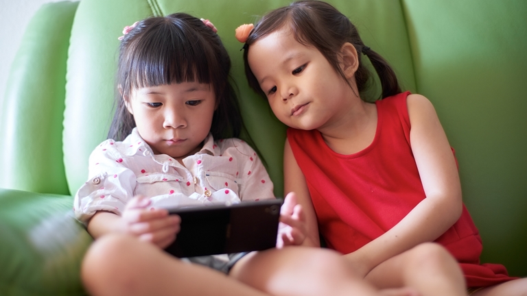 two girls watching mobile phone