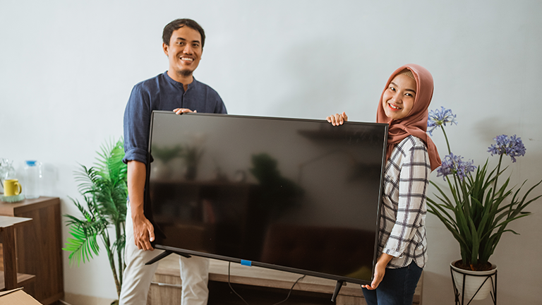 A Malay couple setting up their new TV