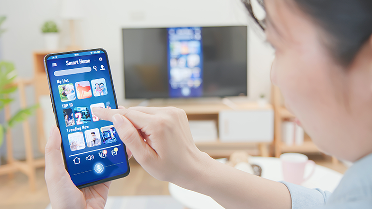 A man browsing smart tv apps on his smartphone