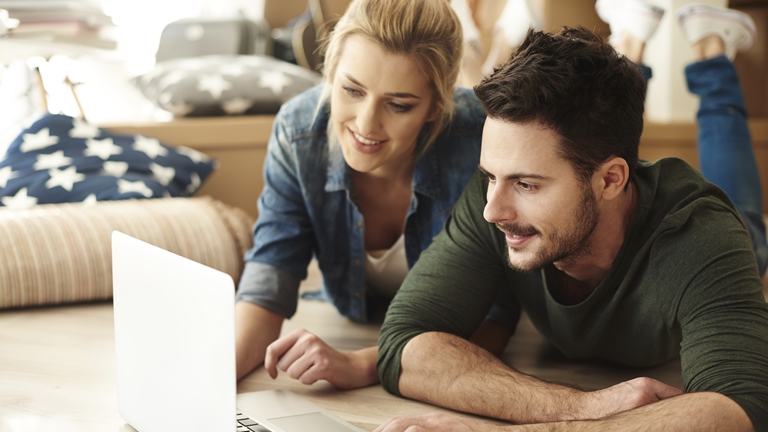 couple using computer on floor