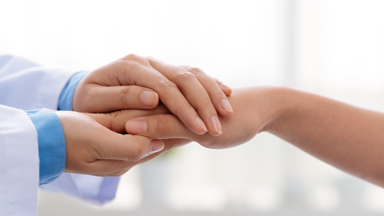 a doctor holding a patient's hand